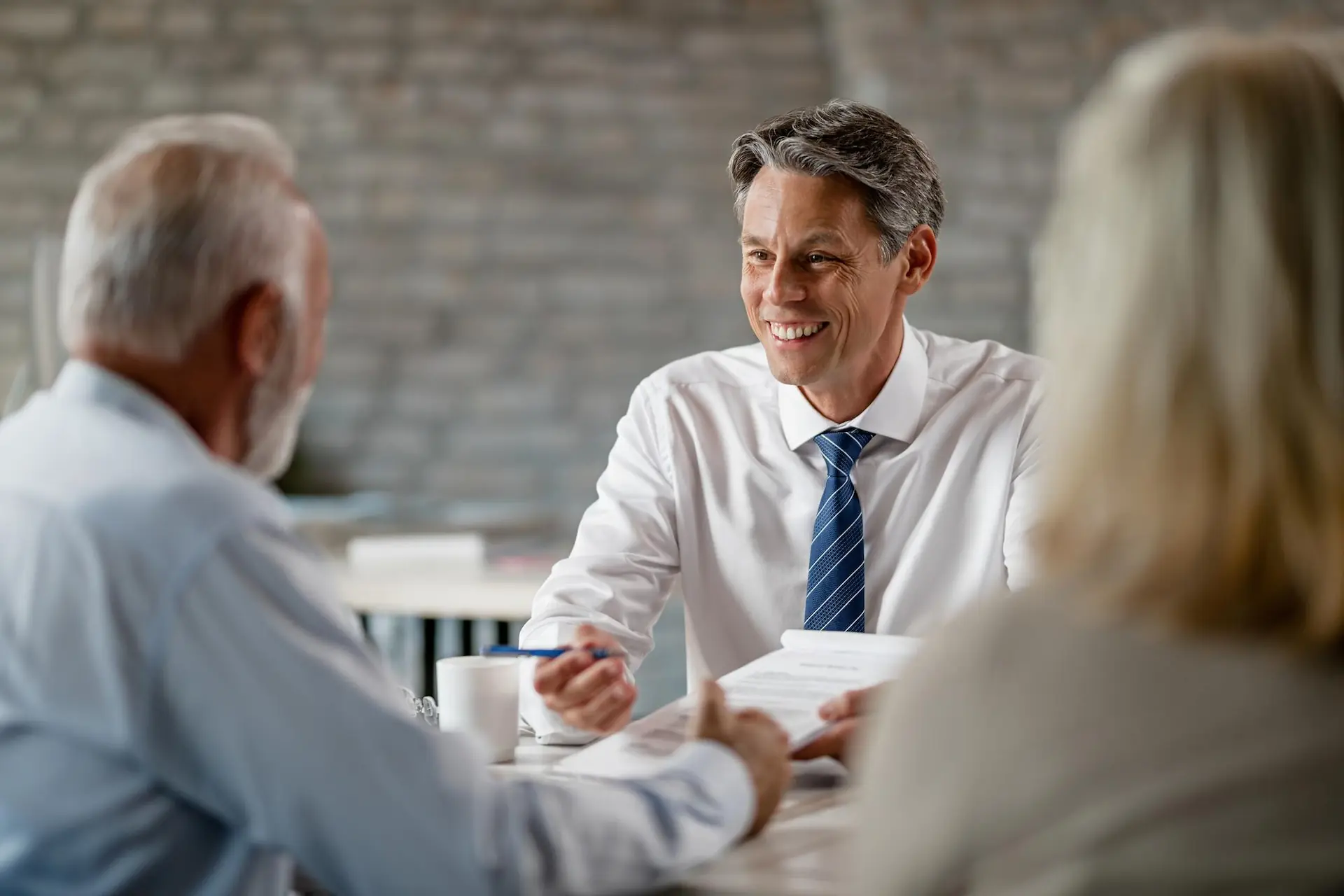 Happy insurance agent communicating with senior clients
