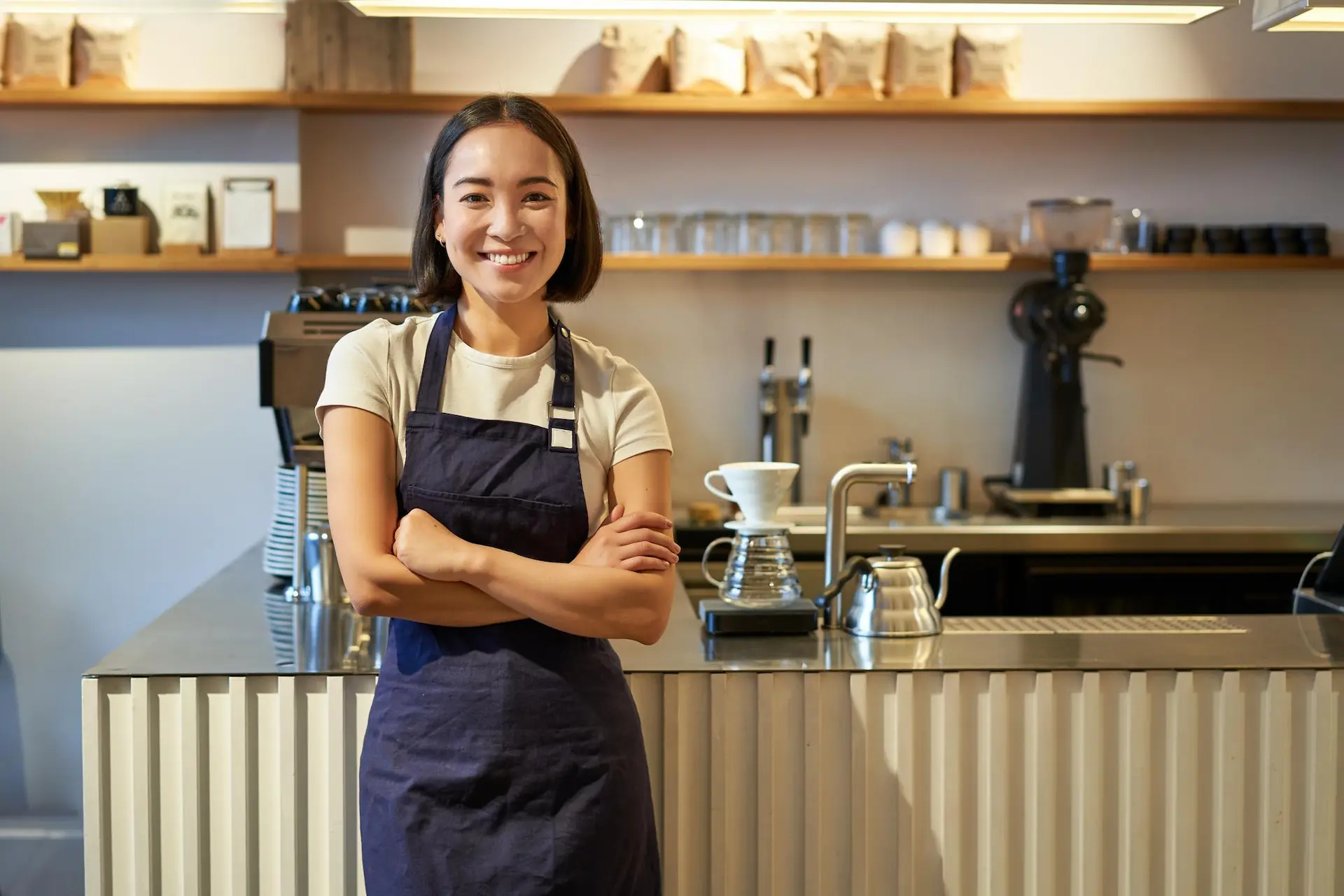 Portrait of smiling asian female barista wearing apron