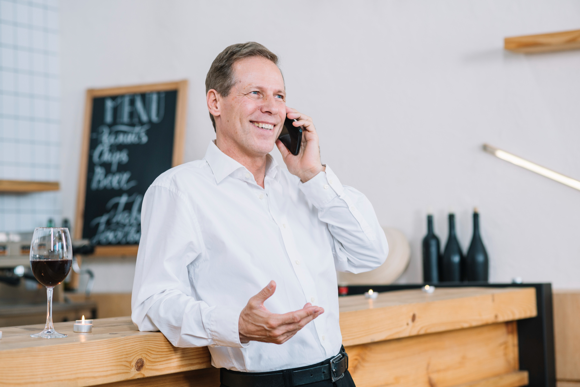 Man leaning on table and talking on phone