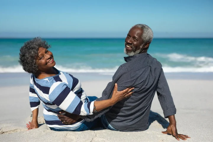 Rear view of a senior African American couple sitting on the beach